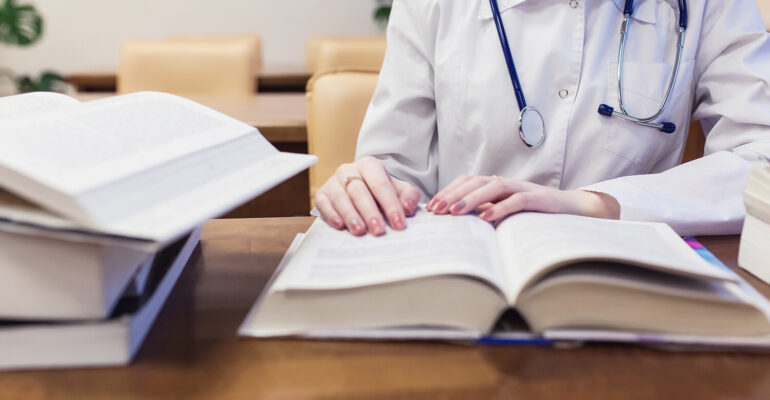 background a medical student for textbooks. The study of surgery by a beautiful girl in the library